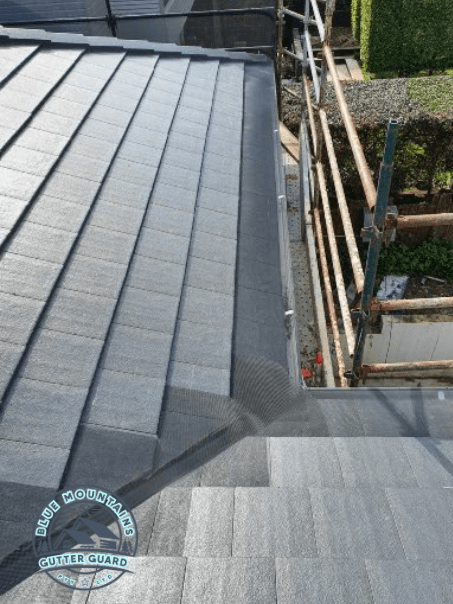 A tile roof and valley featuring a gutter guard installation, effectively preventing debris buildup and ensuring optimal protection.