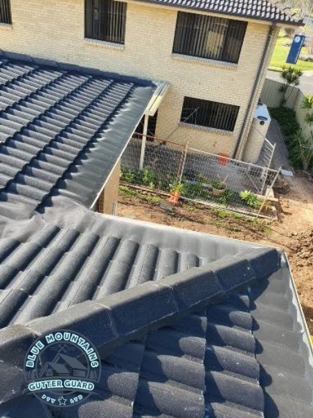 A durable gutter guard installed on a tile roof and valley, ensuring long-lasting performance and protection.