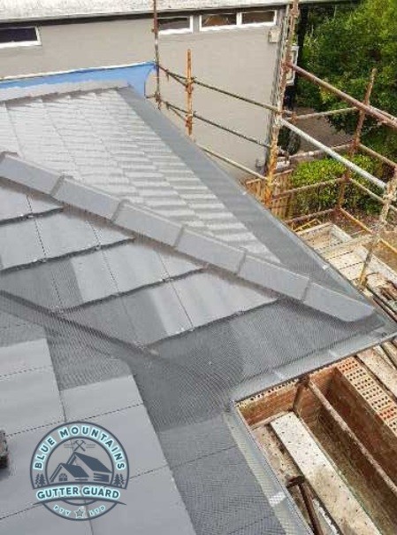 A tile roof and valley with a gutter guard installation, providing enhanced protection against leaves and debris.