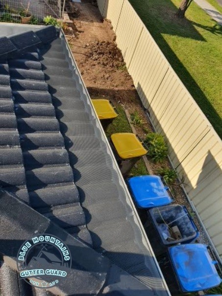 A tile roof featuring a gutter guard installation, effectively preventing debris buildup and ensuring optimal protection.