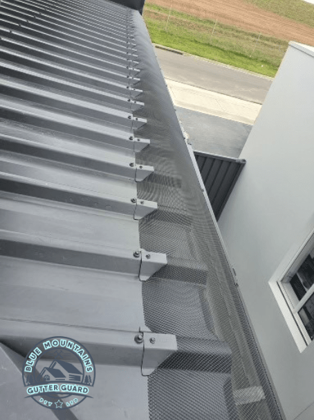 A Trimdek Klip Lok roof featuring a newly installed gutter guard, providing optimal protection against leaves and debris.