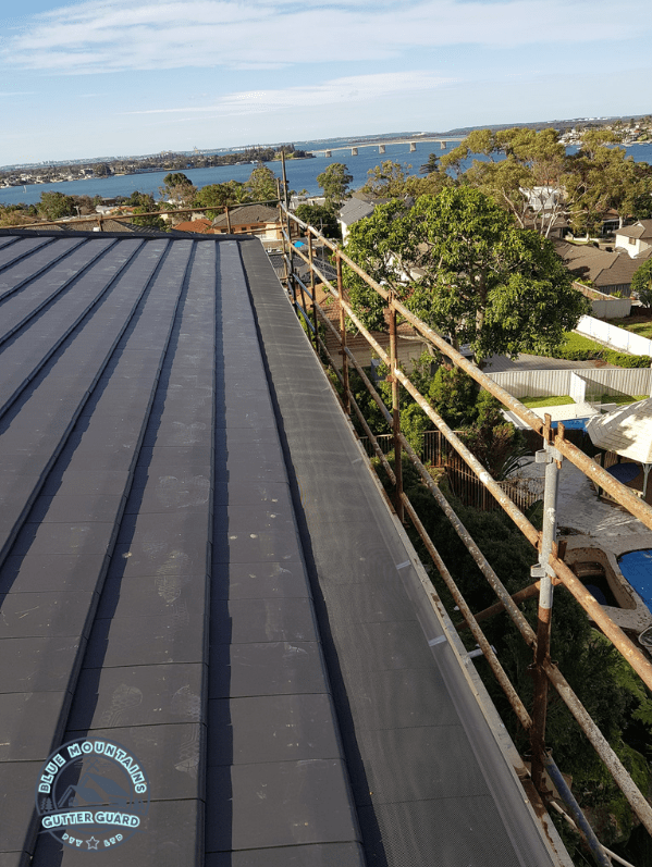 A tile roof featuring a gutter guard installation, effectively preventing debris buildup and ensuring optimal protection.