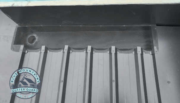 A box gutter equipped with a gutter guard, enhancing home protection by preventing clogs and water damage.